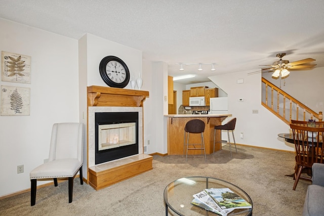 13210 Meadowood Trl NW Unit 63Nw, Coon Rapids, MN 55448 - living room with light colored carpet, a tile fireplace, stairway, baseboards, and a textured ceiling