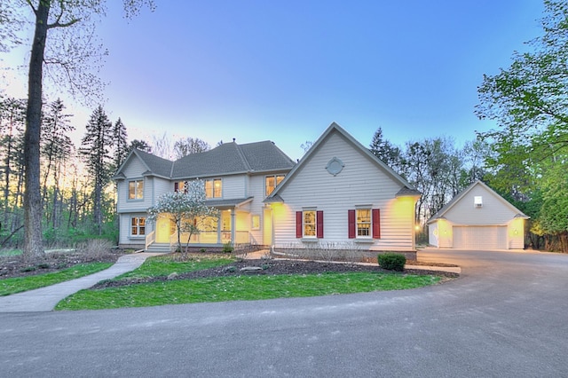 view of front of house with an outdoor structure, a detached garage, and covered porch