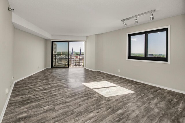 26 10th St W Unit 1701, Saint Paul, MN 55102 - unfurnished room with dark wood-style flooring, baseboards, and rail lighting