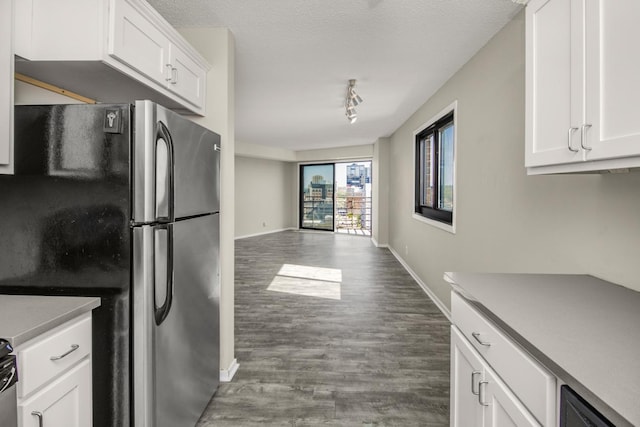 26 10th St W Unit 1701, Saint Paul, MN 55102 - kitchen featuring freestanding refrigerator, wood finished floors, white cabinetry, baseboards, and a textured ceiling