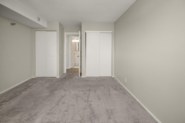 26 10th St W Unit 1701, Saint Paul, MN 55102 - unfurnished bedroom with two closets, carpet flooring, baseboards, and a textured ceiling