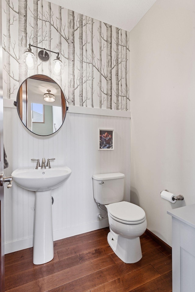 11200 Walnut Ln, Woodbury, MN 55129 - bathroom with hardwood / wood-style floors, toilet, baseboards, and a sink