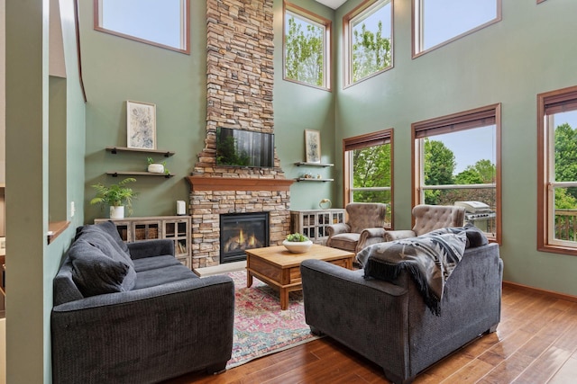 11200 Walnut Ln, Woodbury, MN 55129 - living room featuring a towering ceiling, a fireplace, wood finished floors, and baseboards