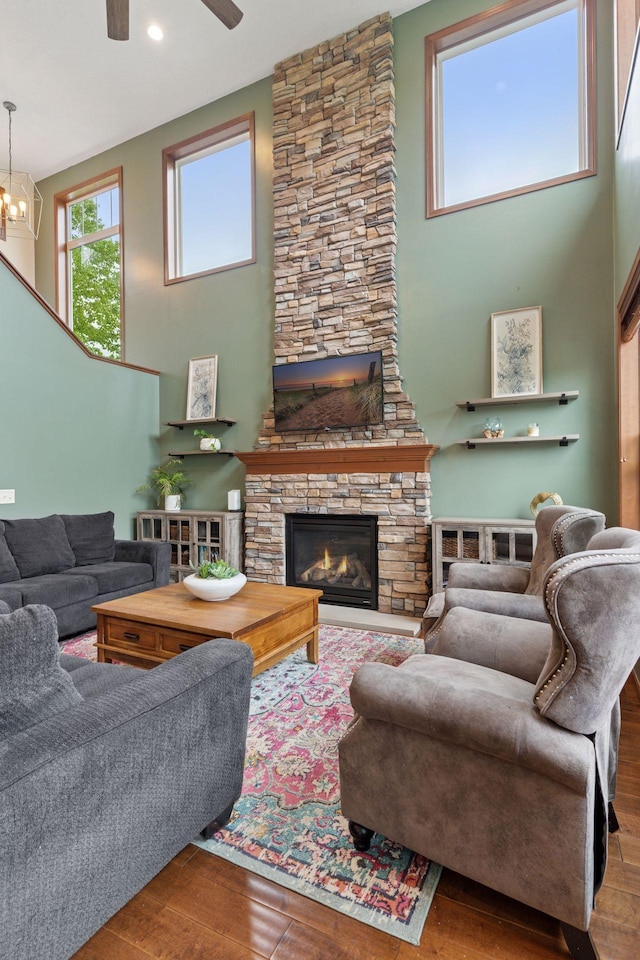 11200 Walnut Ln, Woodbury, MN 55129 - living room with wood finished floors, a high ceiling, a ceiling fan, a stone fireplace, and recessed lighting