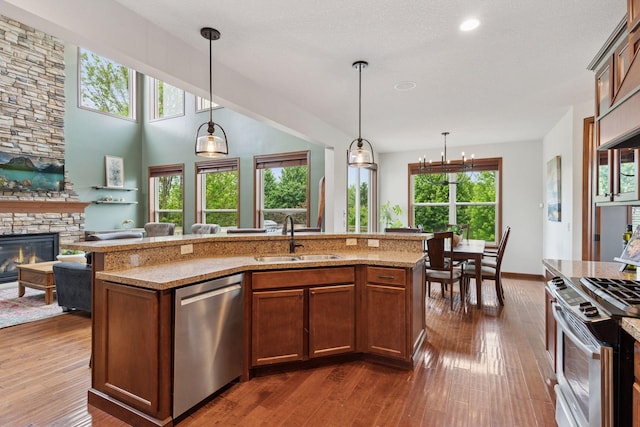 11200 Walnut Ln, Woodbury, MN 55129 - kitchen featuring appliances with stainless steel finishes, a sink, dark wood-style flooring, open floor plan, and light stone countertops