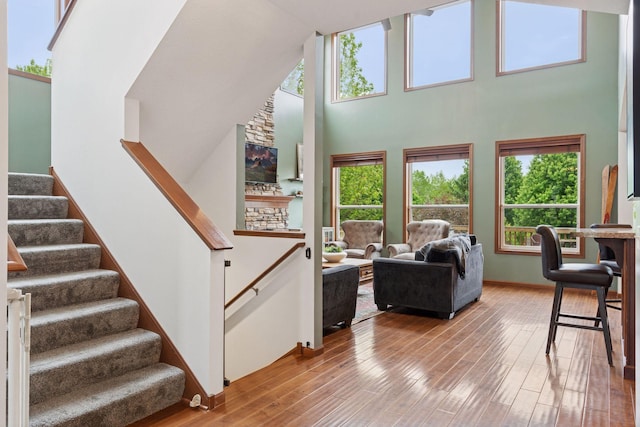11200 Walnut Ln, Woodbury, MN 55129 - living area featuring a high ceiling, wood finished floors, and stairway