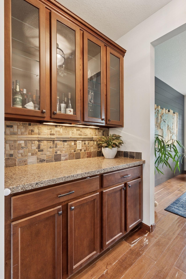 11200 Walnut Ln, Woodbury, MN 55129 - indoor dry bar with tasteful backsplash, wood finished floors, and a textured ceiling