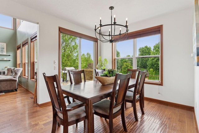 11200 Walnut Ln, Woodbury, MN 55129 - dining area featuring a chandelier, baseboards, and wood-type flooring