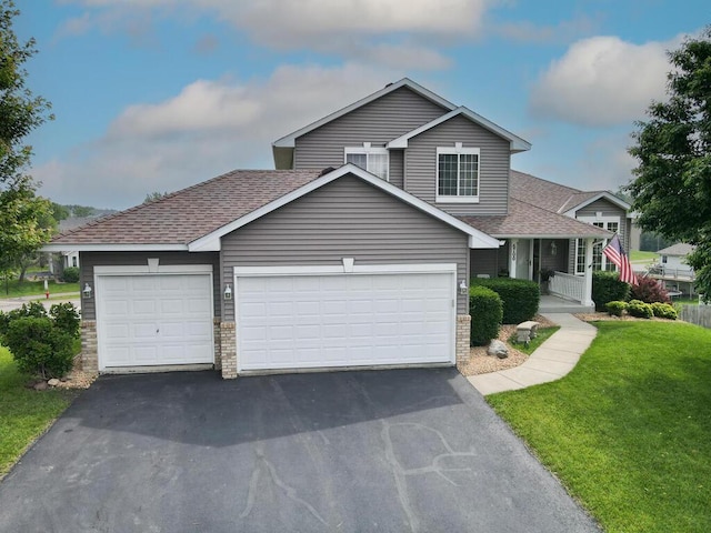 6700 210th Lane Cir N, Forest Lake, MN 55025 - view of front of home with driveway, an attached garage, roof with shingles, a front yard, and covered porch