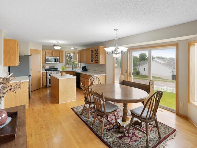 6700 210th Lane Cir N, Forest Lake, MN 55025 - dining area with a chandelier, light wood-style floors, and a textured ceiling