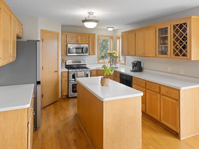 6700 210th Lane Cir N, Forest Lake, MN 55025 - kitchen featuring stainless steel appliances, light wood-style floors, light countertops, and a kitchen island