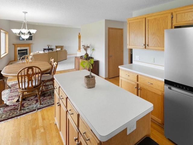 6700 210th Lane Cir N, Forest Lake, MN 55025 - kitchen with freestanding refrigerator, light countertops, light wood finished floors, a textured ceiling, and a chandelier