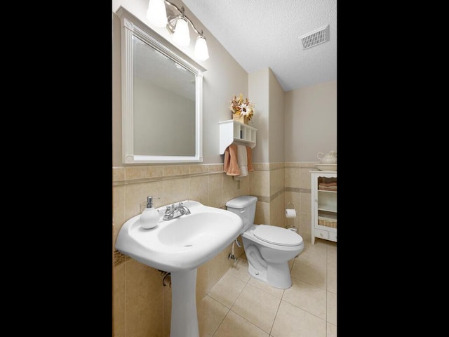 6700 210th Lane Cir N, Forest Lake, MN 55025 - bathroom with tile patterned flooring, a wainscoted wall, tile walls, and a textured ceiling