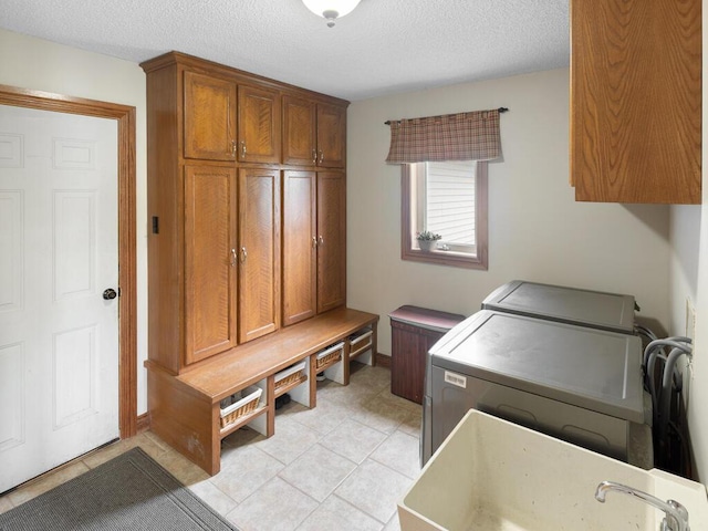 6700 210th Lane Cir N, Forest Lake, MN 55025 - laundry room featuring cabinet space, independent washer and dryer, a textured ceiling, and light tile patterned floors