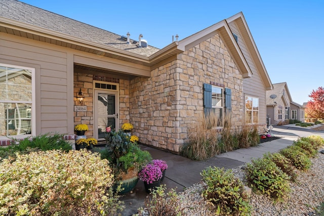 24064 Rivers Edge Rd, Rogers, MN 55374 - doorway to property featuring stone siding and a shingled roof