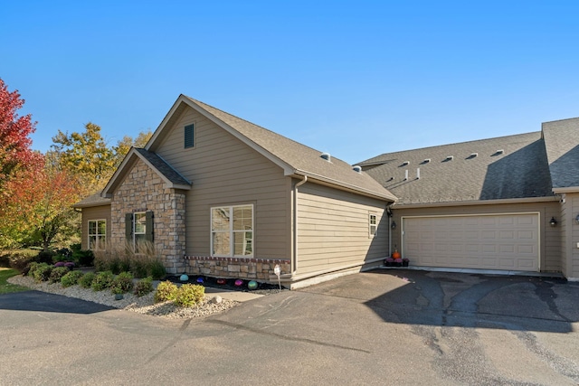 24064 Rivers Edge Rd, Rogers, MN 55374 - view of side of home with driveway, an attached garage, and a shingled roof