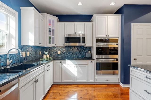 24064 Rivers Edge Rd, Rogers, MN 55374 - kitchen with stainless steel appliances, a sink, white cabinetry, recessed lighting, and backsplash