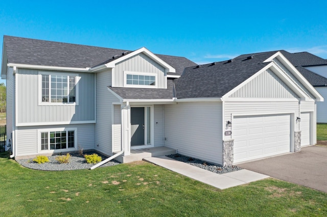 1120 7th Ave NE, Isanti, MN 55040 - view of front of property with an attached garage, a front yard, asphalt driveway, board and batten siding, and roof with shingles