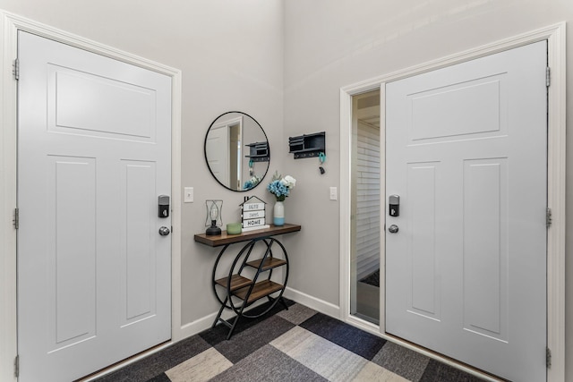 1120 7th Ave NE, Isanti, MN 55040 - foyer entrance with baseboards and dark carpet