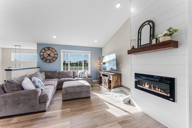 1120 7th Ave NE, Isanti, MN 55040 - living room featuring wood finished floors, a fireplace, recessed lighting, and high vaulted ceiling