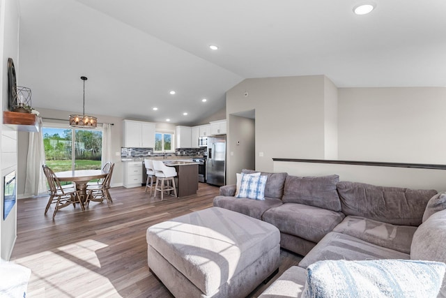1120 7th Ave NE, Isanti, MN 55040 - living area featuring wood finished floors, recessed lighting, a chandelier, and high vaulted ceiling