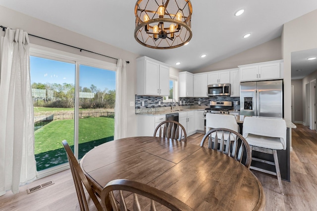 1120 7th Ave NE, Isanti, MN 55040 - dining space featuring vaulted ceiling, light wood-style flooring, plenty of natural light, a chandelier, and recessed lighting