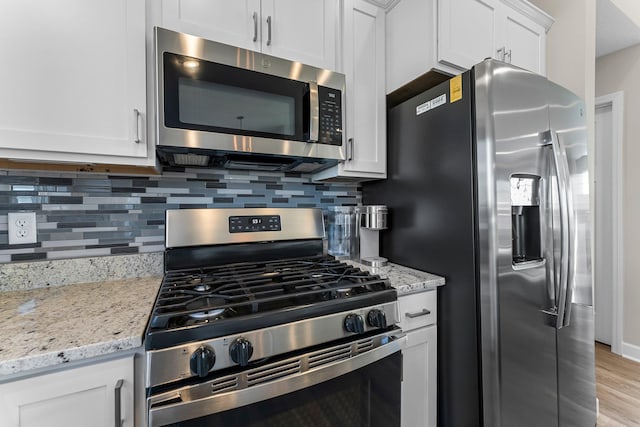 1120 7th Ave NE, Isanti, MN 55040 - kitchen with stainless steel appliances, backsplash, white cabinetry, and light stone counters