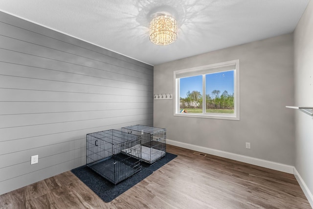 1120 7th Ave NE, Isanti, MN 55040 - unfurnished bedroom featuring wood finished floors and a chandelier