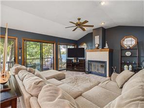 1555 Bluebird Ln, Mound, MN 55364 - living area featuring lofted ceiling, a ceiling fan, a tiled fireplace, and recessed lighting