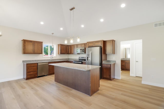 31079 Magnolia Ridge Way, Lindstrom, MN 55045 - kitchen featuring appliances with stainless steel finishes, a kitchen island, light wood-style floors, brown cabinetry, and baseboards