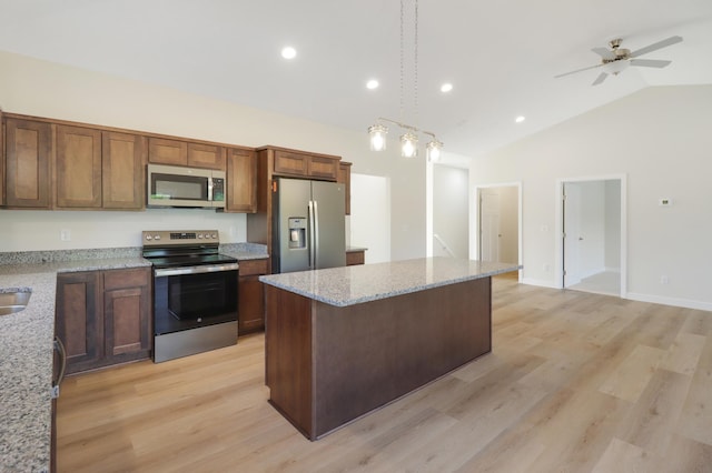 31079 Magnolia Ridge Way, Lindstrom, MN 55045 - kitchen with stainless steel appliances, vaulted ceiling, a kitchen island, light wood-type flooring, and hanging light fixtures