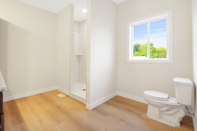 31079 Magnolia Ridge Way, Lindstrom, MN 55045 - bathroom with toilet, a tile shower, baseboards, wood finished floors, and vanity