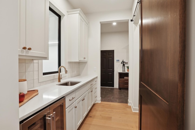 10320 Peony Ln N, Maple Grove, MN 55311 - kitchen featuring a sink, wine cooler, light countertops, light wood-type flooring, and tasteful backsplash