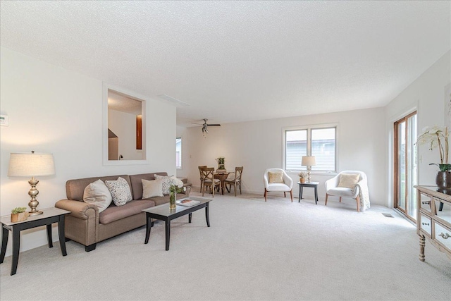 13721 Inglewood Ave, Savage, MN 55378 - living room featuring light carpet, healthy amount of natural light, a ceiling fan, and a textured ceiling