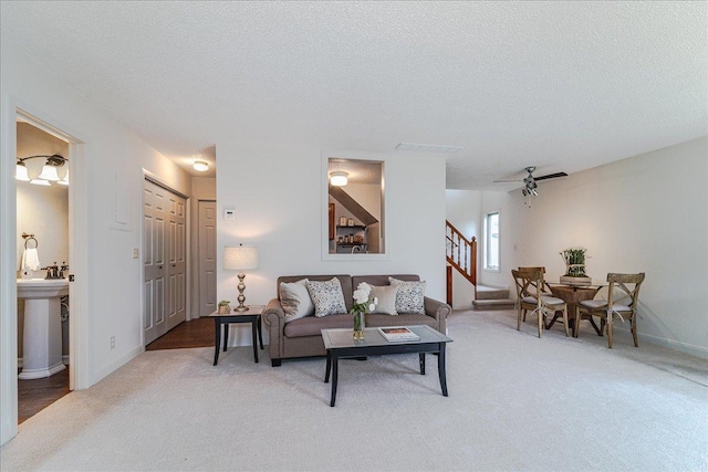 13721 Inglewood Ave, Savage, MN 55378 - living room with stairway, light colored carpet, a textured ceiling, baseboards, and a ceiling fan