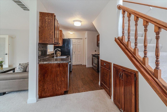 13721 Inglewood Ave, Savage, MN 55378 - kitchen featuring stainless steel stove, dark countertops, dark wood-style floors, a sink, and a textured ceiling