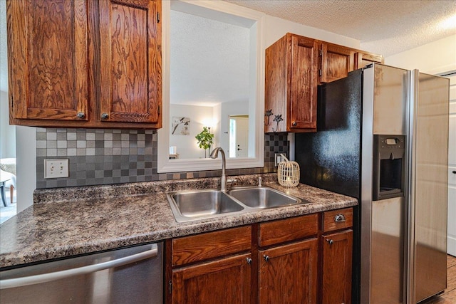 13721 Inglewood Ave, Savage, MN 55378 - kitchen with stainless steel appliances, a sink, dark countertops, tasteful backsplash, and a textured ceiling