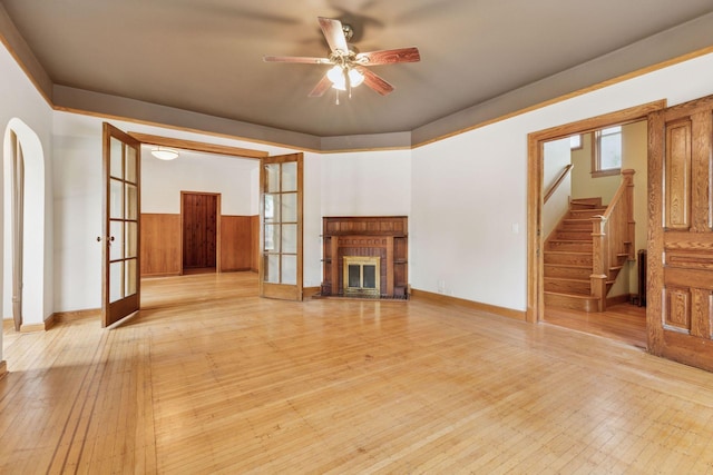 518 32nd St, Minneapolis, MN 55408 - unfurnished living room with a ceiling fan, stairs, french doors, a fireplace, and light wood-style floors