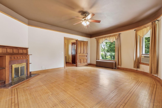 518 32nd St, Minneapolis, MN 55408 - unfurnished living room with radiator, ceiling fan, light wood finished floors, and a fireplace