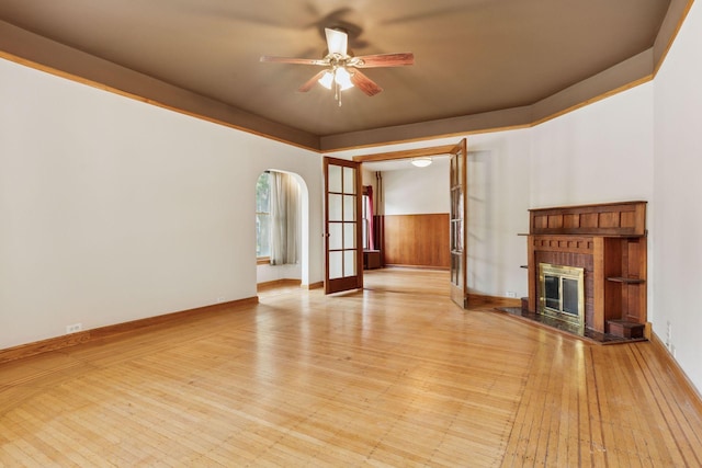 518 32nd St, Minneapolis, MN 55408 - unfurnished living room featuring a ceiling fan, hardwood / wood-style floors, a brick fireplace, and arched walkways