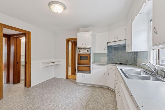 518 32nd St, Minneapolis, MN 55408 - kitchen featuring oven, a warming drawer, exhaust hood, white cabinets, and stainless steel gas stovetop