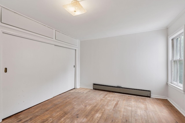 518 32nd St, Minneapolis, MN 55408 - unfurnished bedroom with a baseboard radiator, wood-type flooring, and a closet
