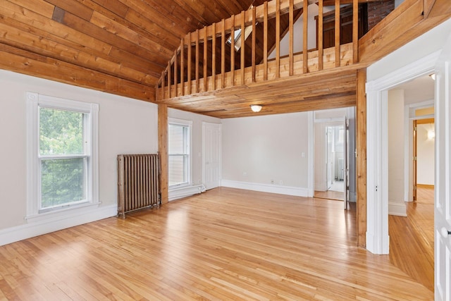 518 32nd St, Minneapolis, MN 55408 - spare room featuring light wood-style flooring, vaulted ceiling, and radiator heating unit