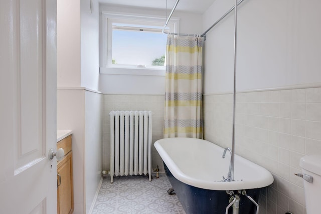 518 32nd St, Minneapolis, MN 55408 - full bath with radiator heating unit, a freestanding bath, tile walls, vanity, and a shower with shower curtain
