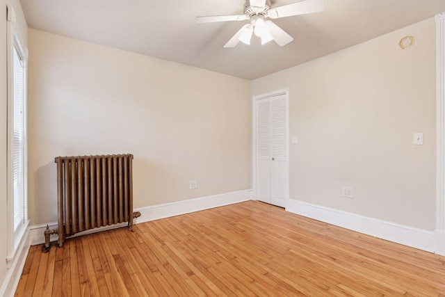 518 32nd St, Minneapolis, MN 55408 - spare room featuring radiator, light wood-type flooring, and a ceiling fan