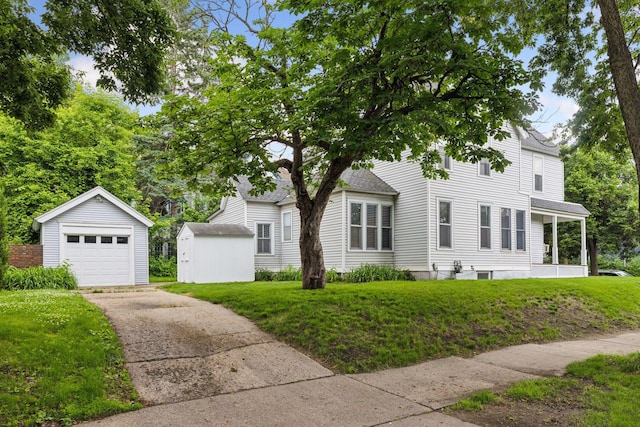 518 32nd St, Minneapolis, MN 55408 - view of front of house with an outdoor structure, concrete driveway, a detached garage, a front yard, and a shingled roof