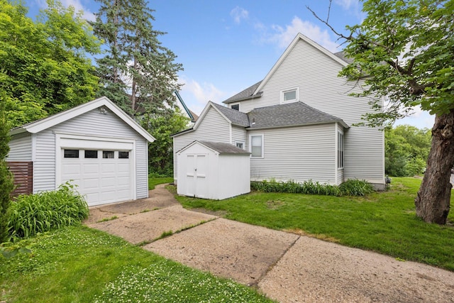 518 32nd St, Minneapolis, MN 55408 - back of property featuring an outdoor structure, driveway, a garage, a yard, and a shingled roof