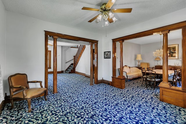 sitting room featuring carpet, a ceiling fan, stairway, and a textured ceiling