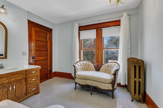 sitting room with radiator and baseboards