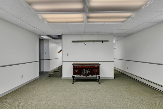 finished below grade area with a baseboard radiator, carpet floors, stairway, a paneled ceiling, and baseboards